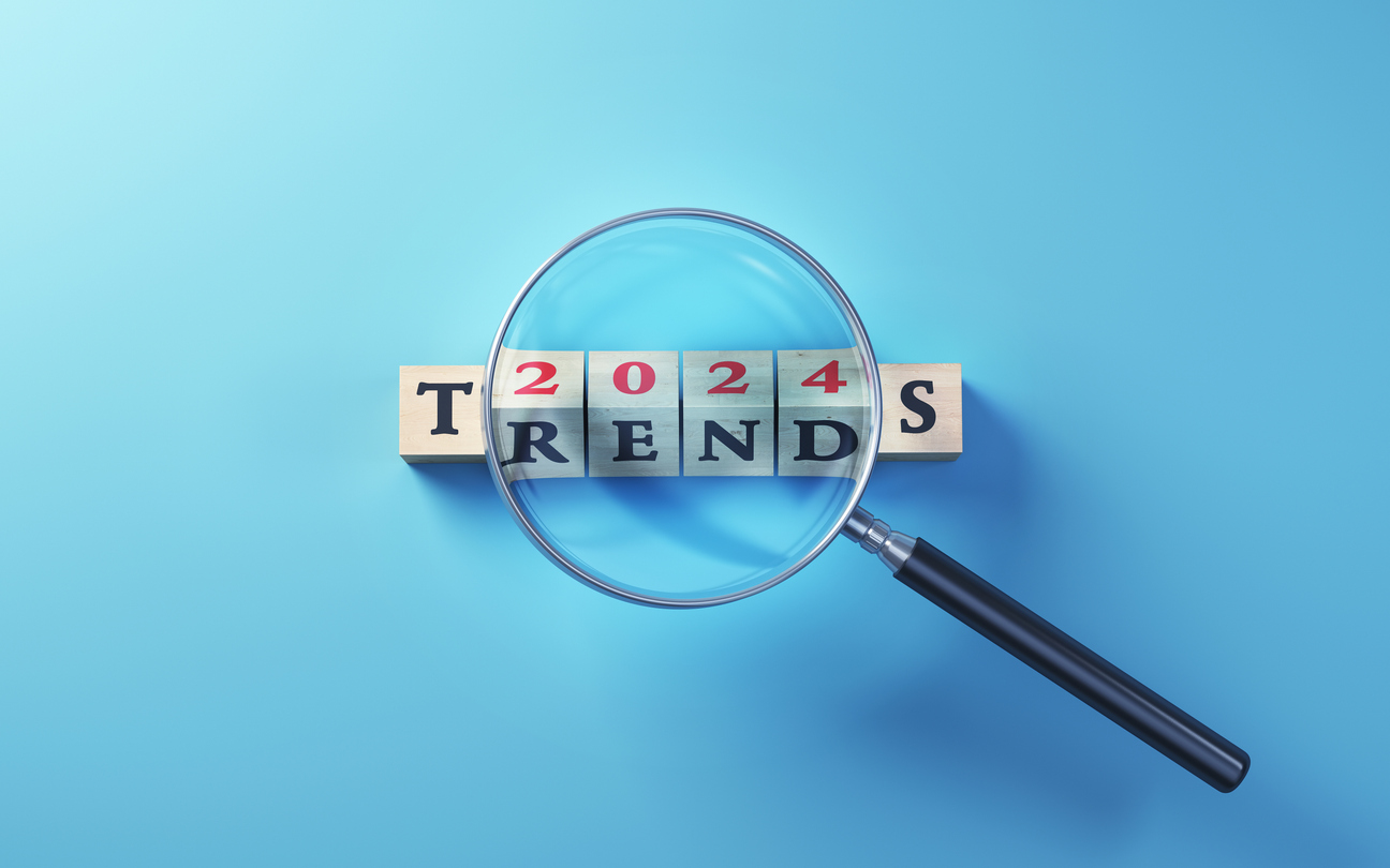 2024 Trends Written on Wooden Blocks Standing Selected with Magnifying Glass on Blue Background